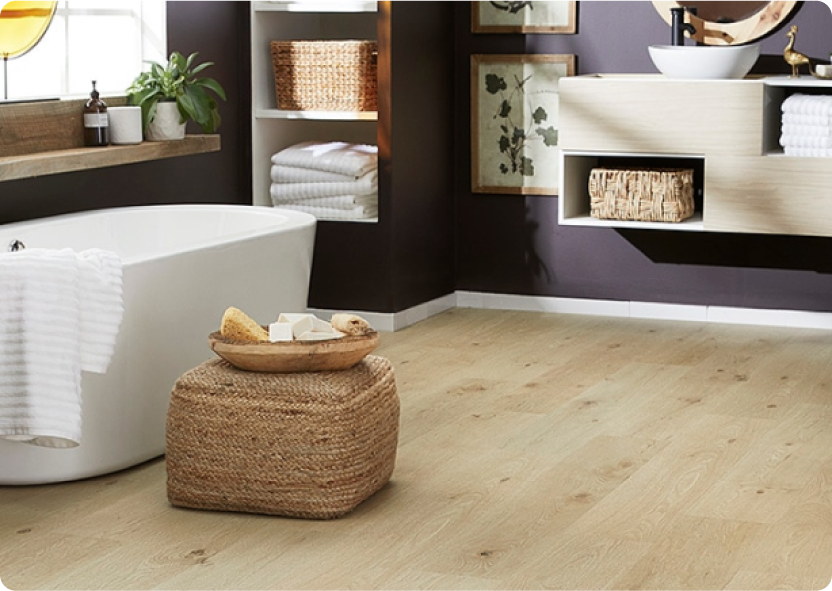 Light wood-look laminate floors in a bathroom with a white stand-alone tub.
