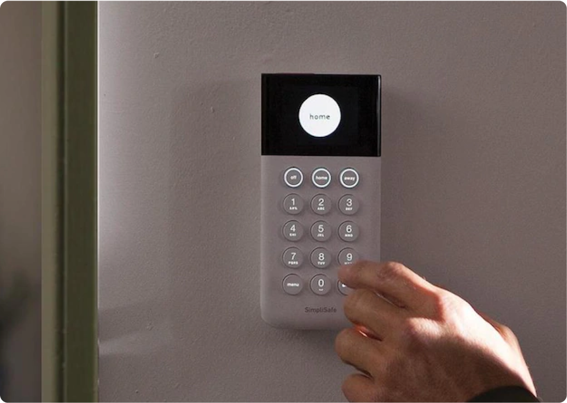 A person setting an alarm on a security system.