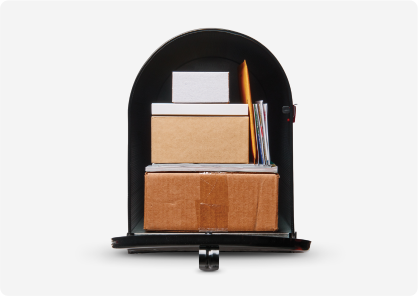 An extra-large black mailbox full of boxes and mail.