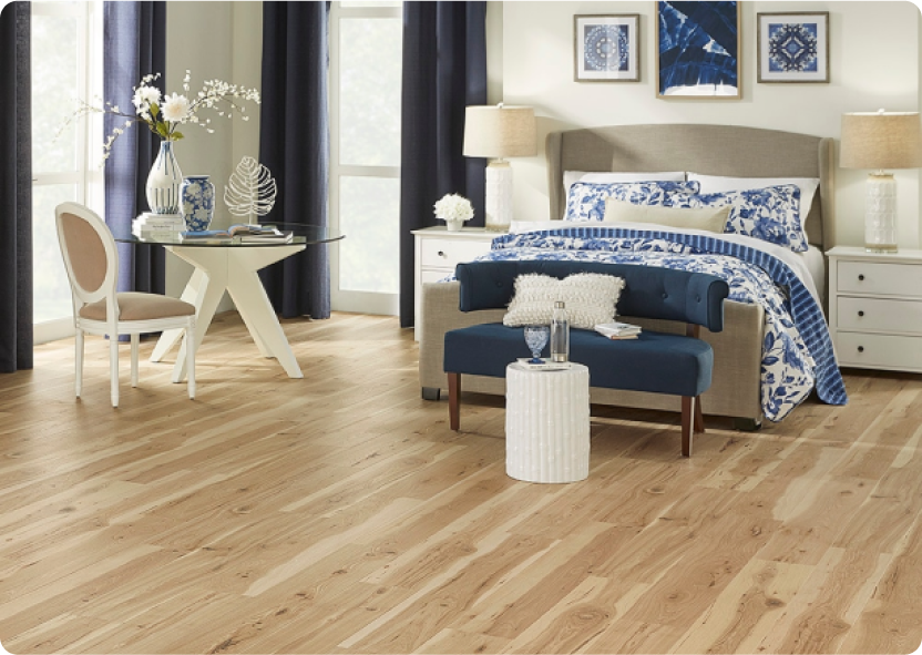 Light wood-look laminate flooring in a bedroom decorated in neutrals, blues and whites.