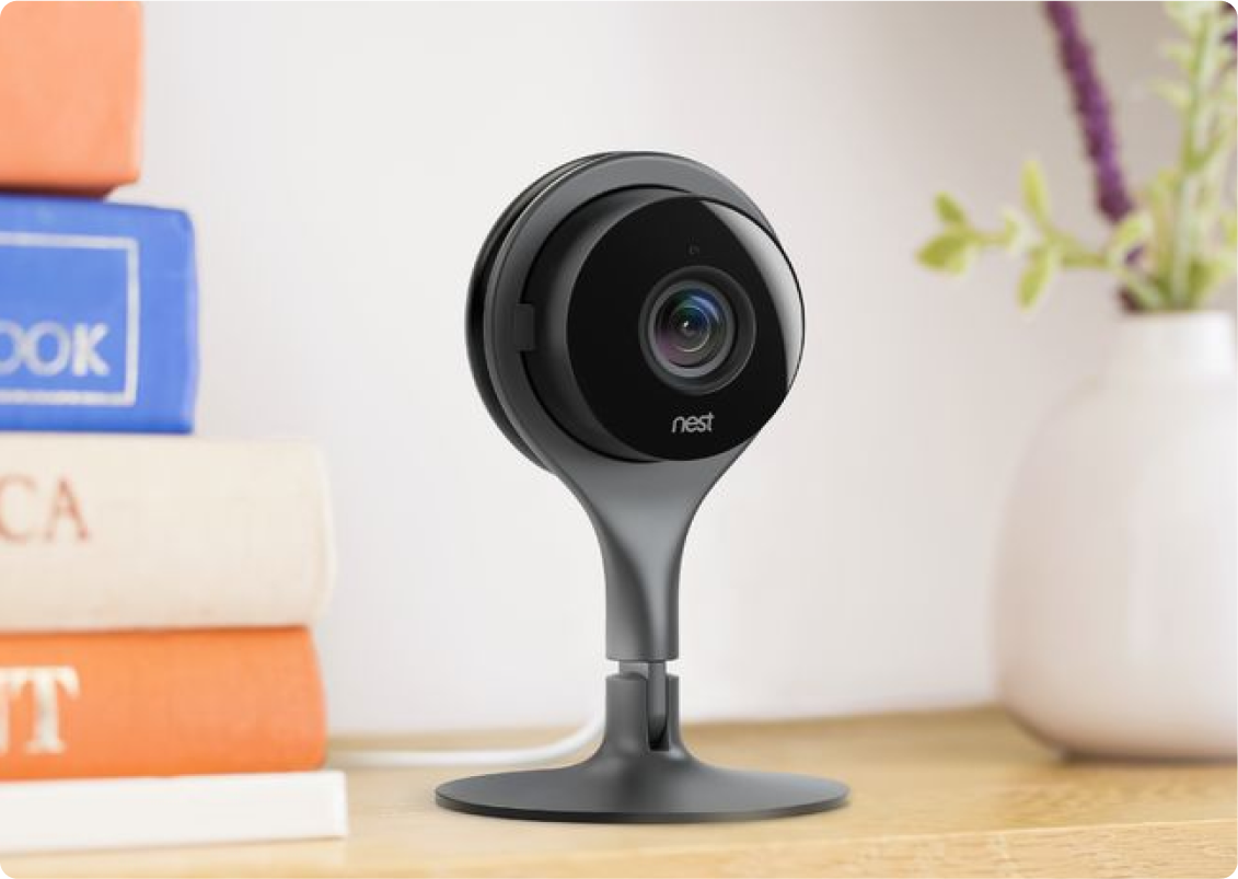 A security camera next to a stack of books.