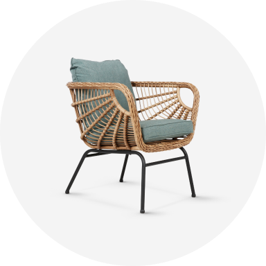 A dark brown wicker patio set with a couch, 2 chairs and 2 ottomans with navy blue cushions.